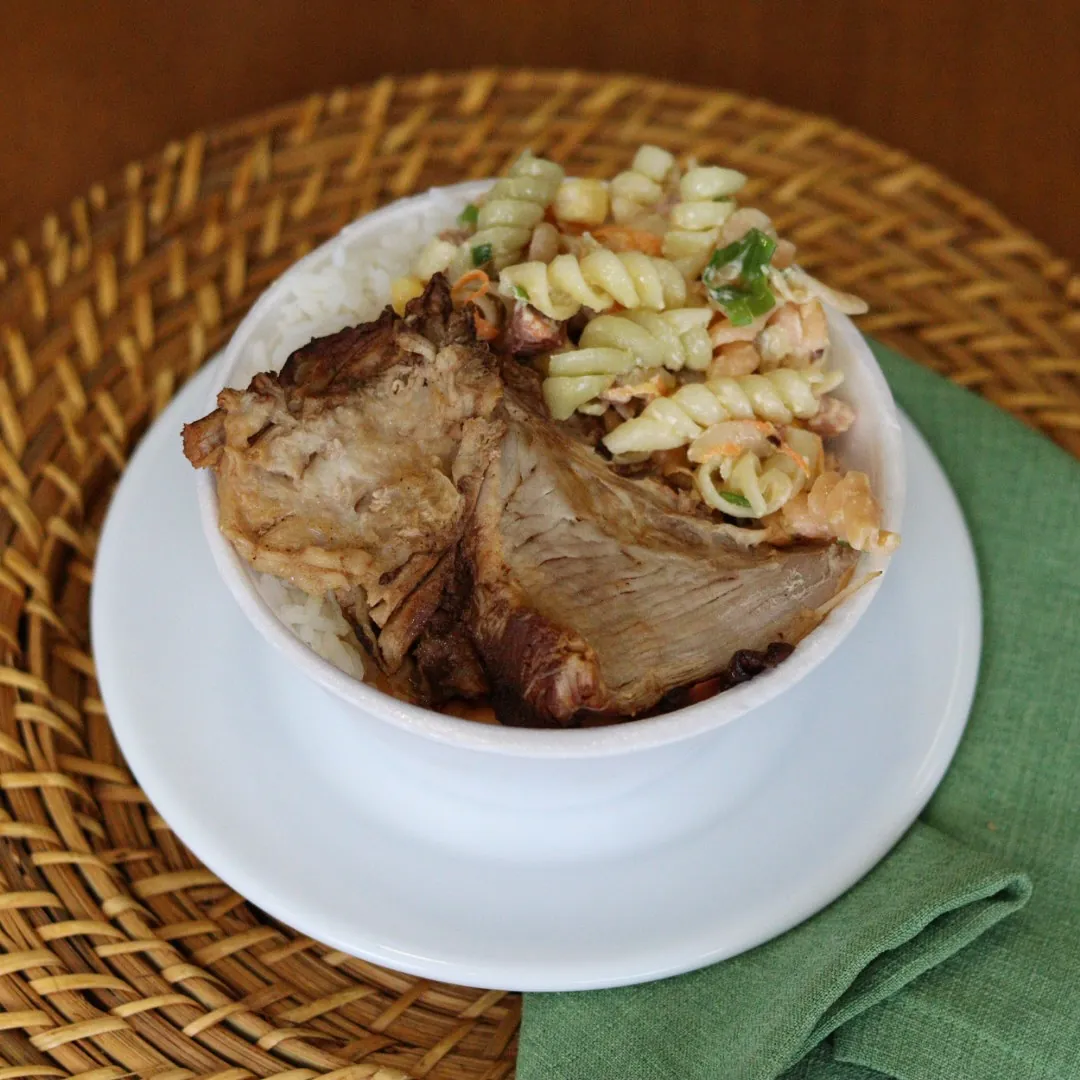 Prato com carne de porco assada e salada de macarrão